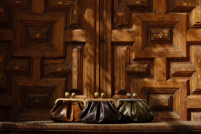 Weekend Max Mara Pasticcino bags against carved Spanish woodwork